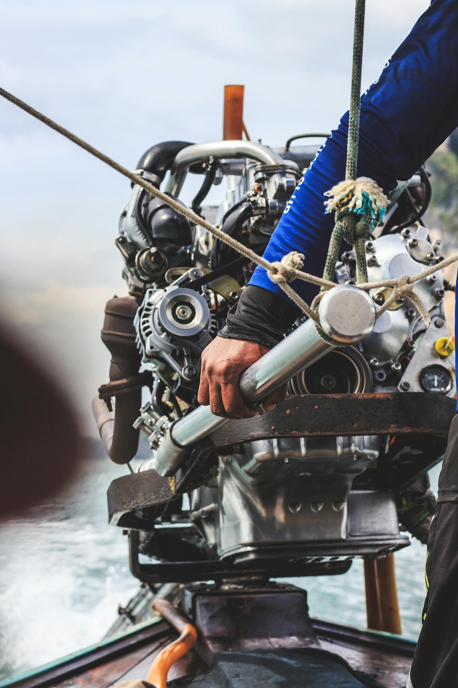 Mains de mécanicien travaillant sur un moteur de yacht à l'atelier